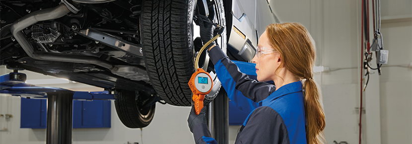 A Subaru technician checking tire pressure. | Mark Miller Subaru South Towne in Sandy UT
