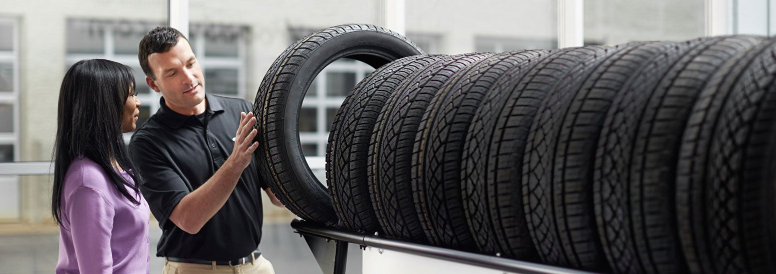 Subaru service representative showing customer a tire. | Mark Miller Subaru South Towne in Sandy UT