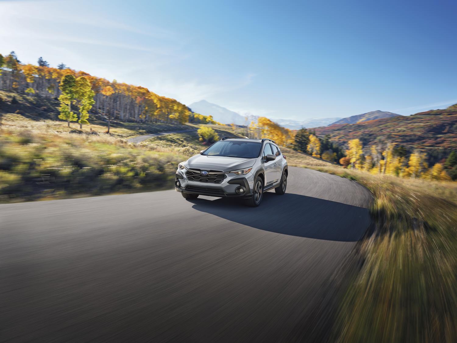 2026 Subaru Crosstrek in white on a mountain road during fall colors