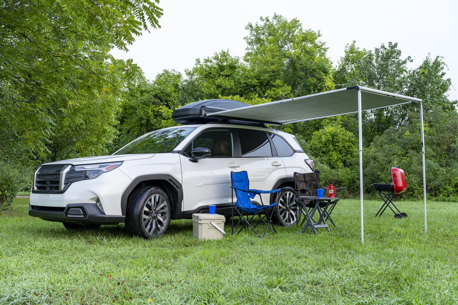 2026 Subaru Trailseeker in white at a campsite with a Thule awning extended